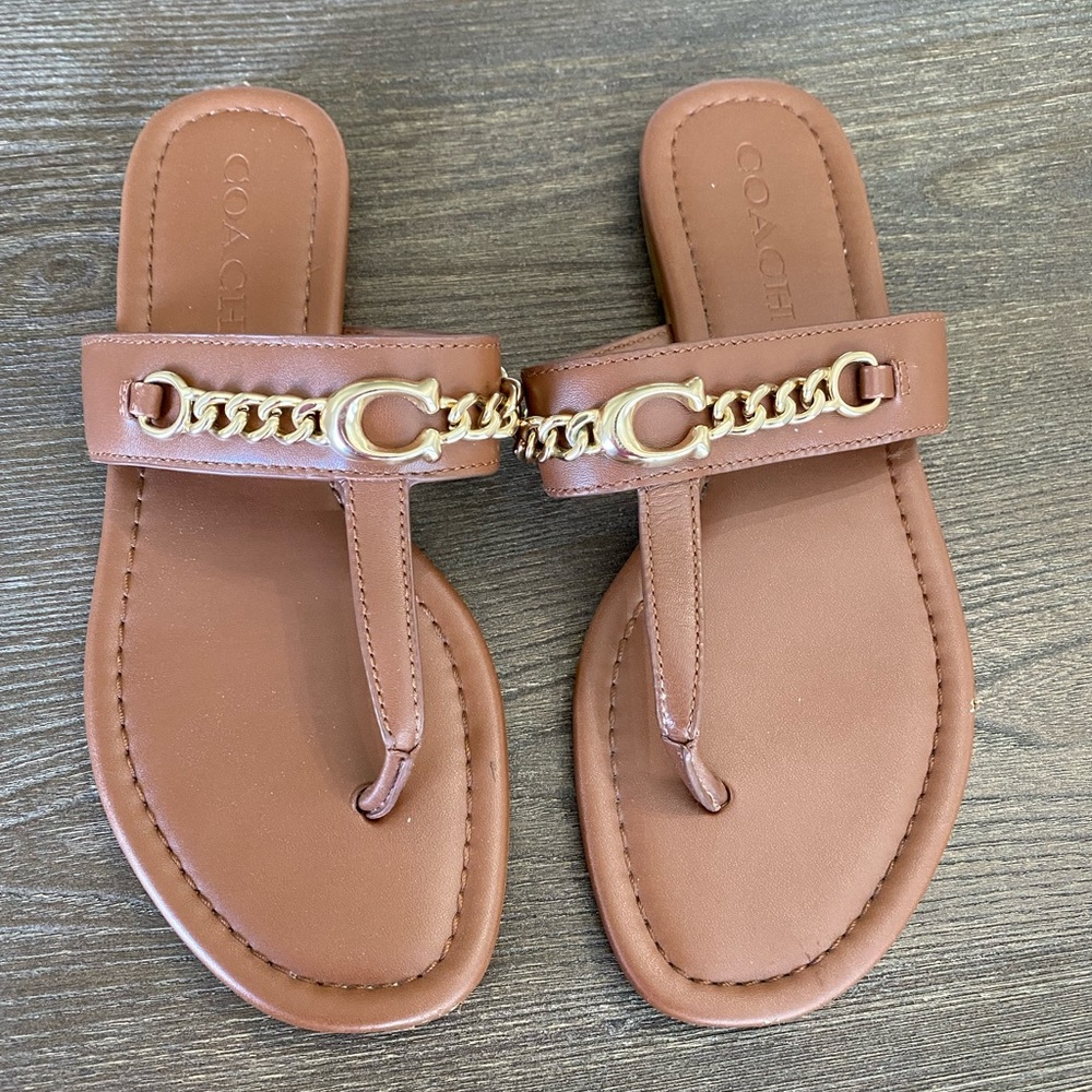 Brown coach flip flops with gold chains